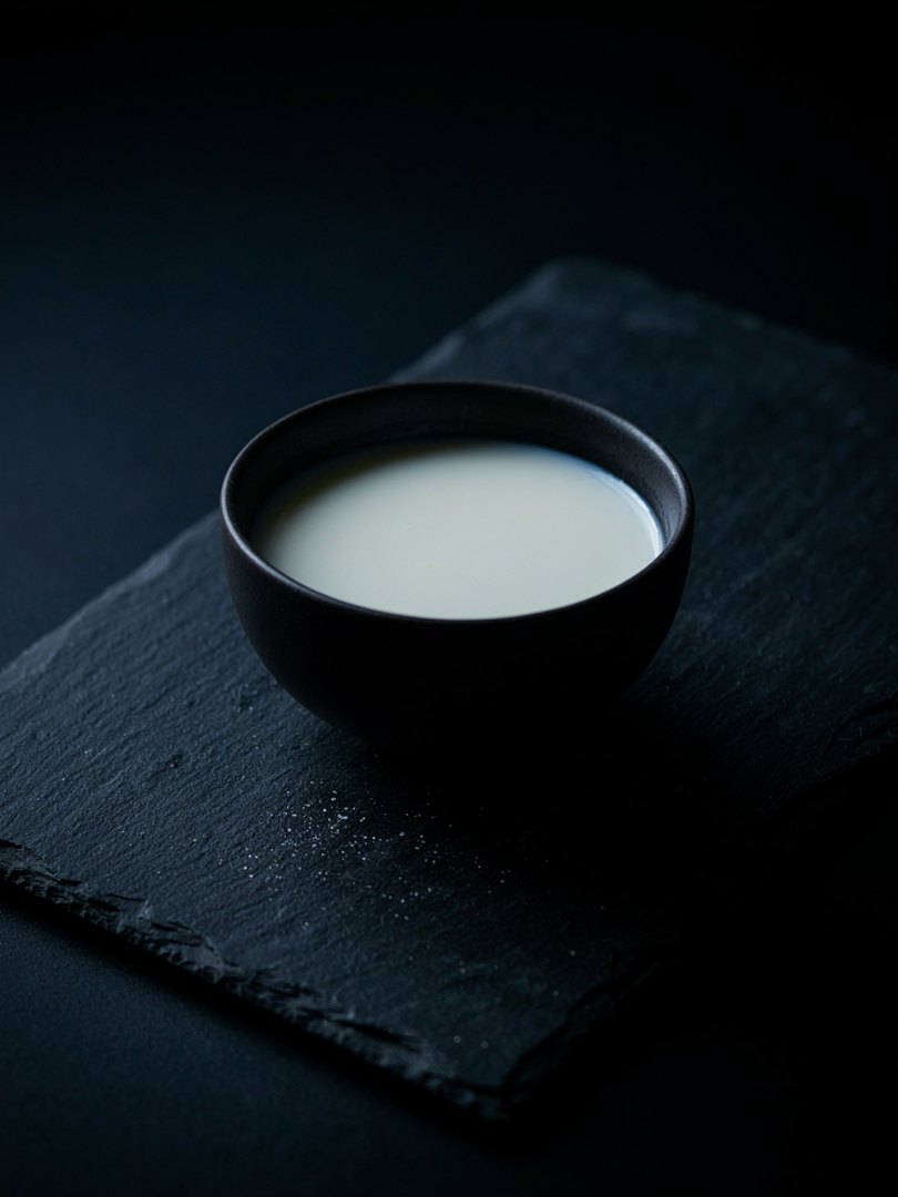 Un cuenco de leche sobre pizarra oscura
